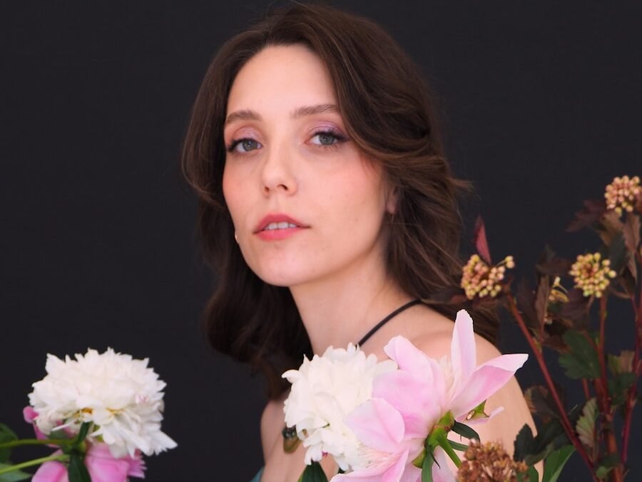 A woman in a blue dress holding a bouquet of flowers