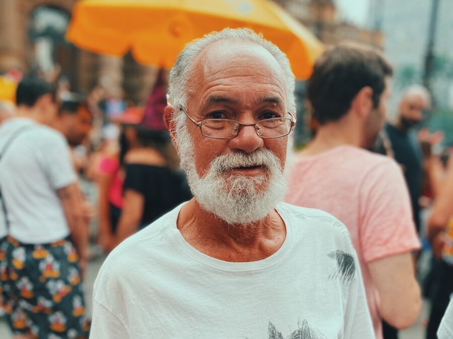 man in white crew neck t-shirt standing near people during daytime