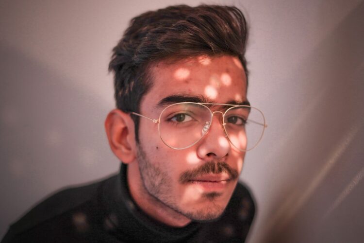 man in black crew neck shirt wearing silver framed eyeglasses