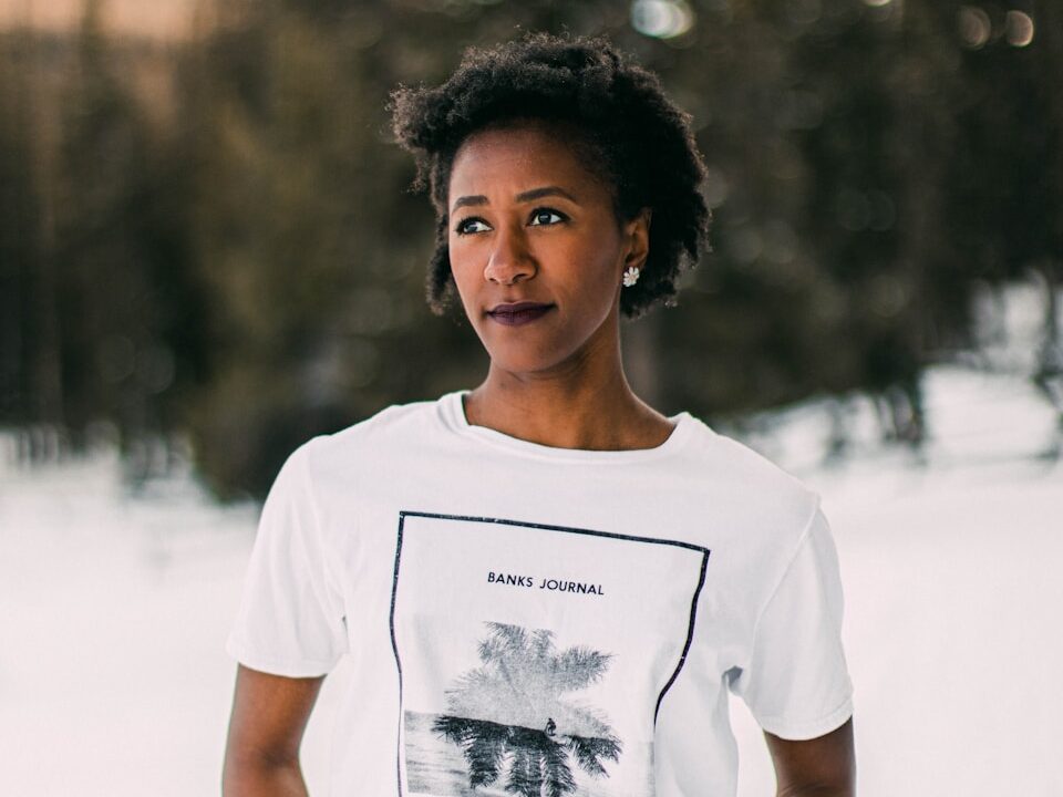 woman in white crew neck t-shirt standing on white sand during daytime