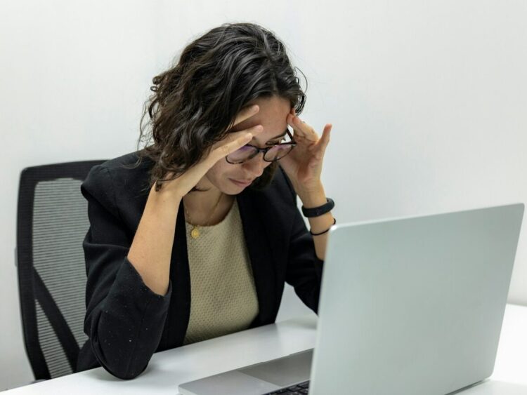 a woman sitting in front of a laptop computer
