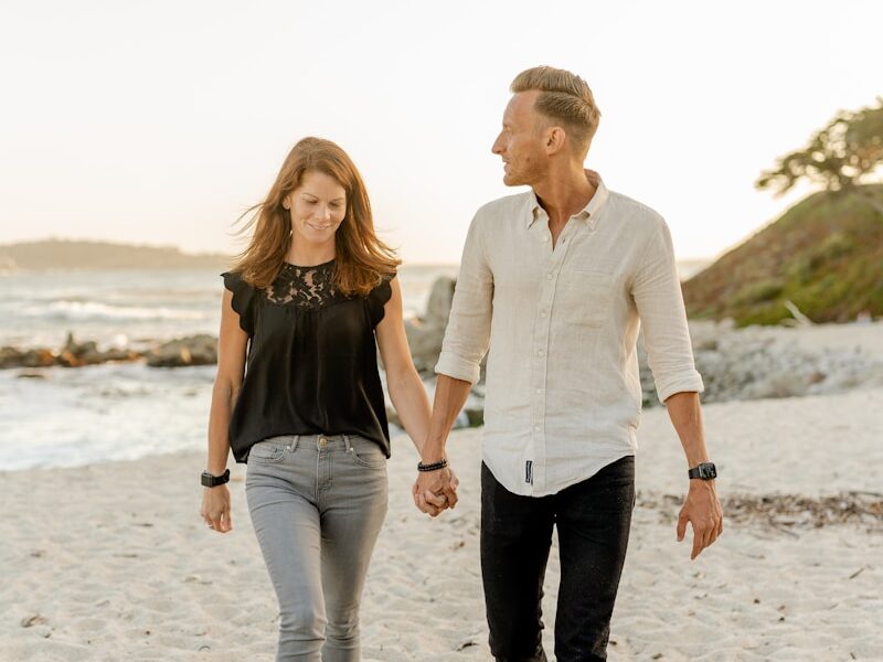 man and woman standing on beach during daytime