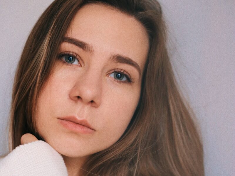a woman in a white sweater posing for a picture
