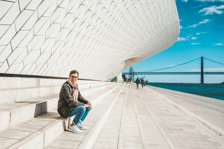 a man sitting on a stone bench in front of a building