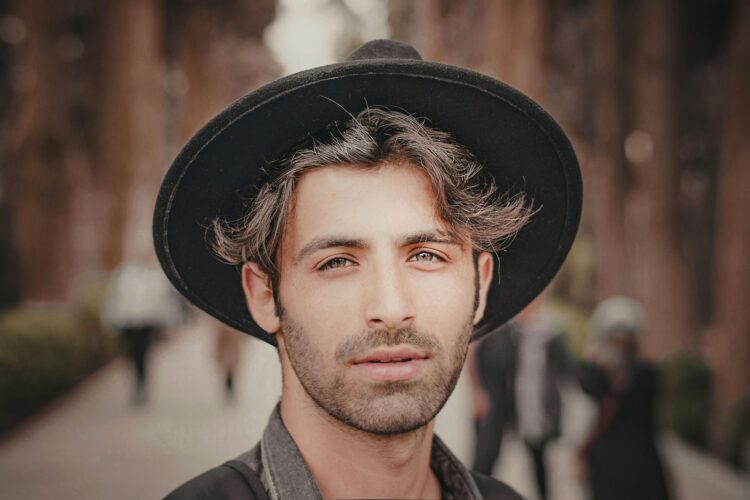 a man wearing a black hat on a city street