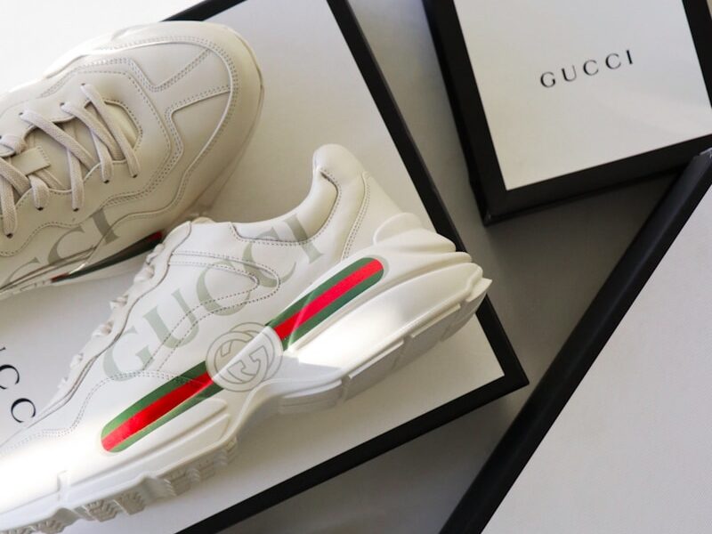 a pair of white sneakers sitting on top of a box