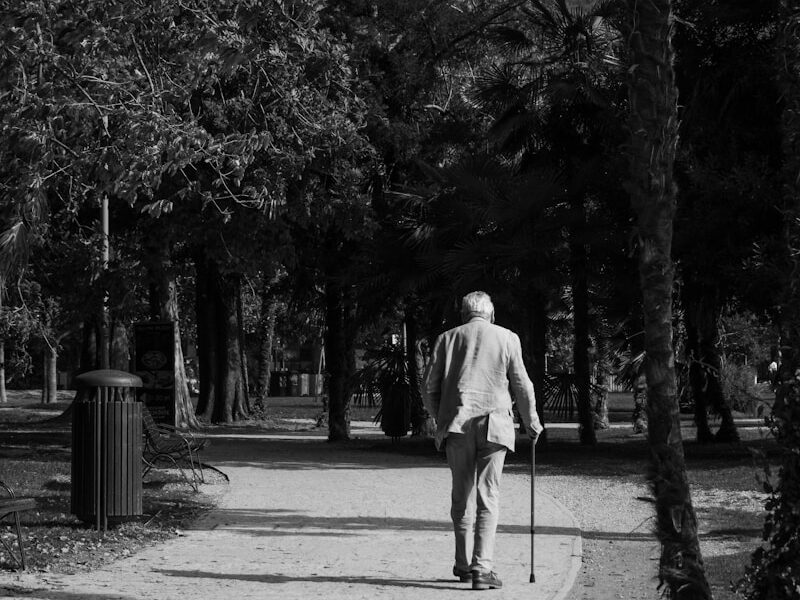 a black and white photo of a man walking down a path