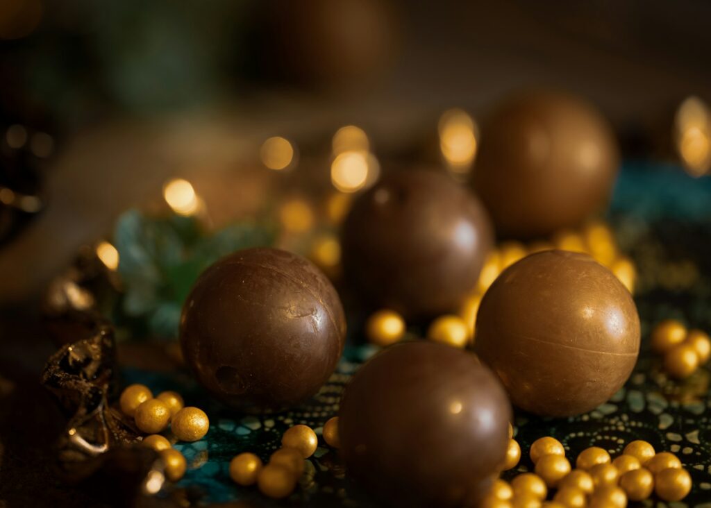 a table topped with chocolate balls and gold beads