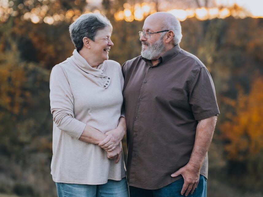 A man and woman standing next to each other in a field