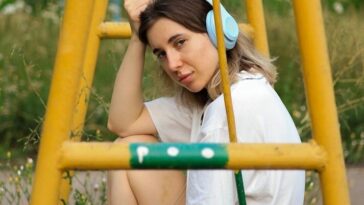 a woman sitting on a swing in a park