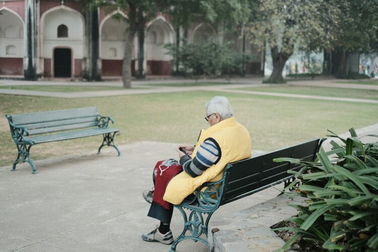 a man sitting on a bench in a park