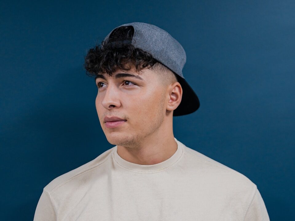 a young man wearing a hat and a t - shirt