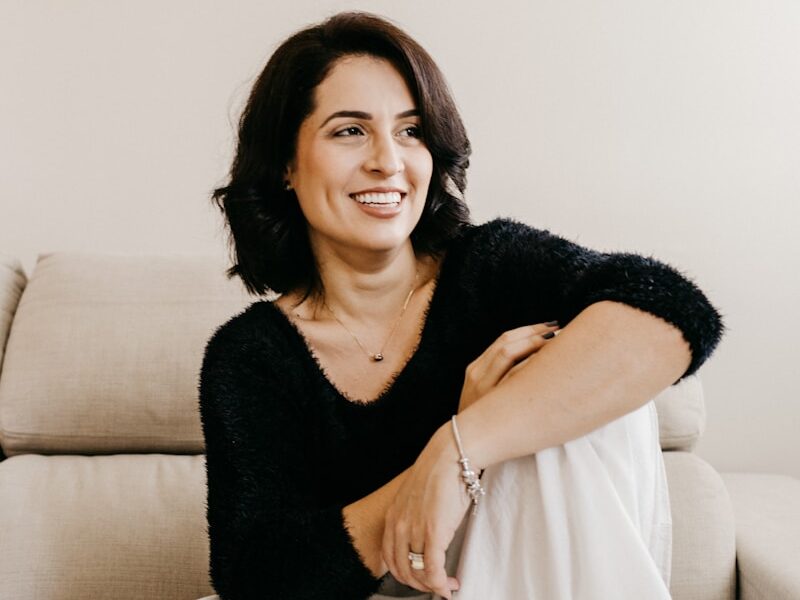 woman in black long sleeve shirt sitting on white couch