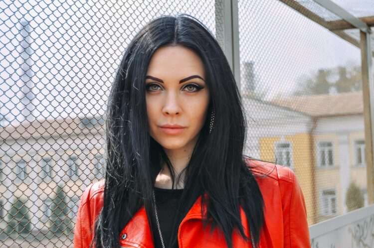 a woman with long black hair wearing a red jacket