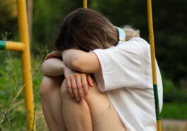 a woman sitting on a swing with her legs crossed