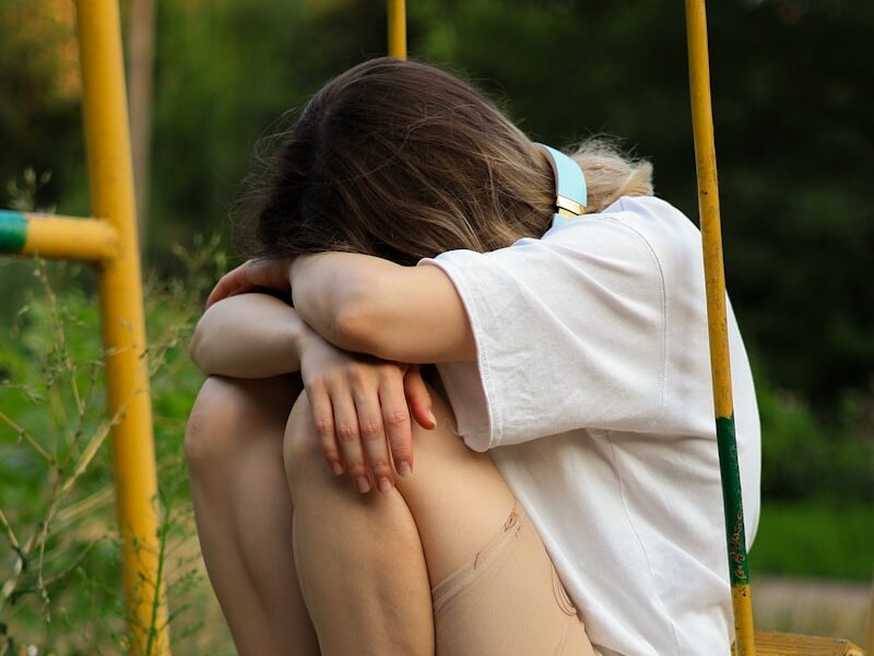 a woman sitting on a swing with her legs crossed