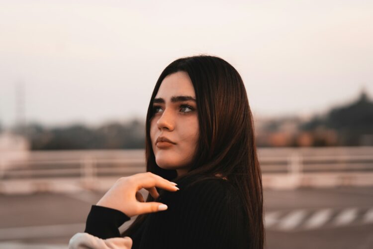 a woman with long brown hair is posing for a picture