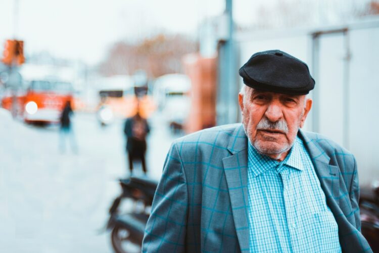 man in blue and white plaid dress shirt wearing black fedora hat