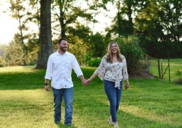 couple walking at grass lawn away from tree