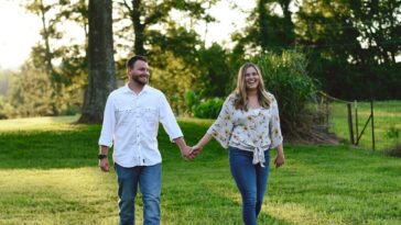 couple walking at grass lawn away from tree