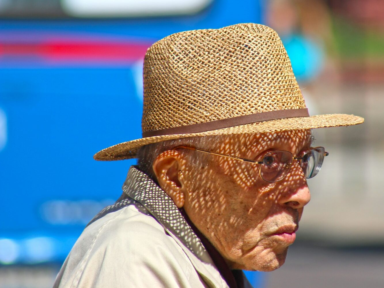 An old man wearing a straw hat and glasses