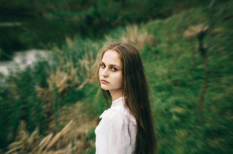 A woman with long hair standing in a field