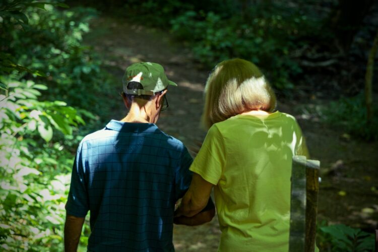 a man and a woman are walking in the woods