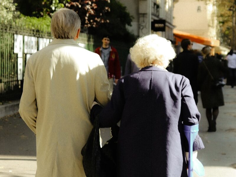 a couple of people walking down a sidewalk