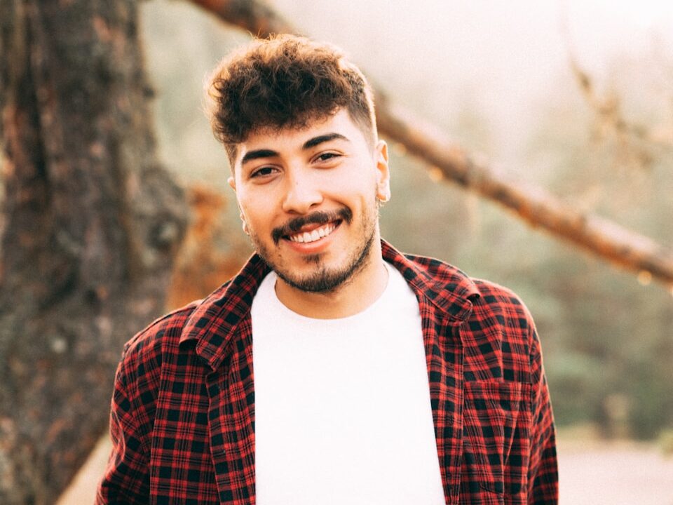 a man standing in front of a tree smiling