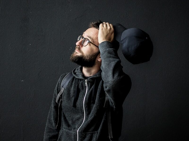 man looking up holding his hair