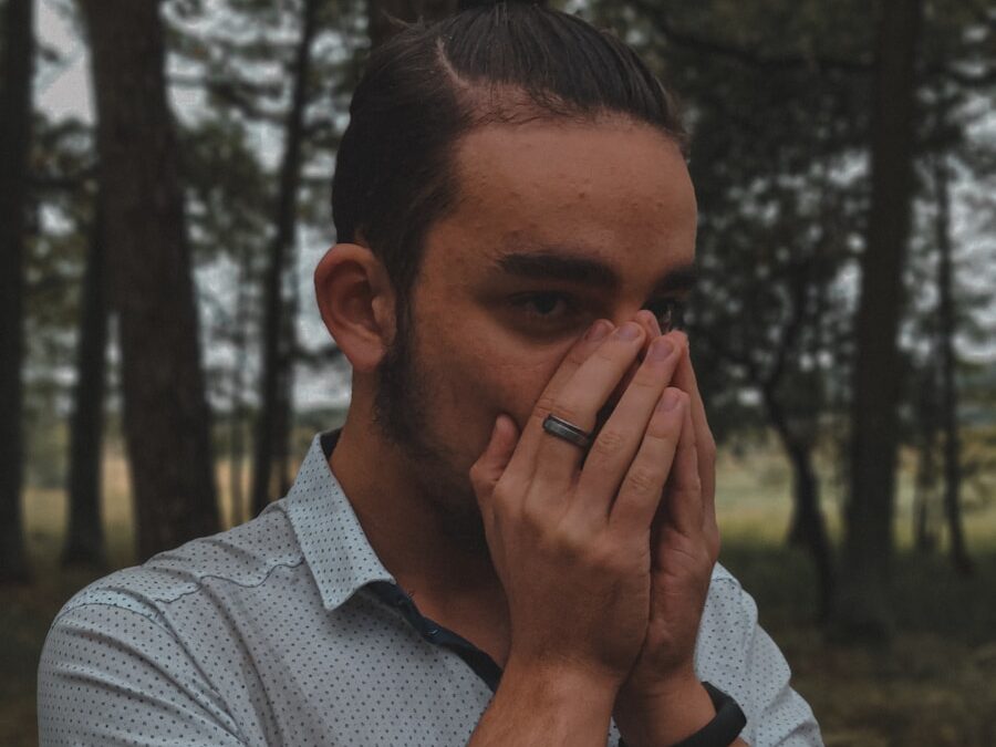 a man covers his face with his hands