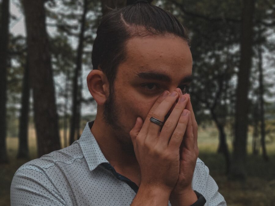 a man covers his face with his hands