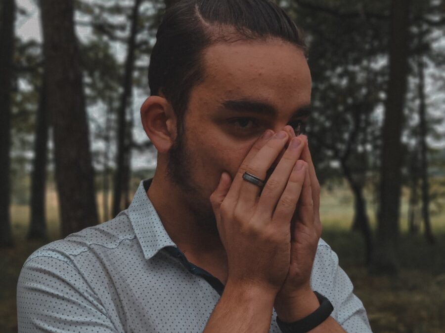 a man covers his face with his hands