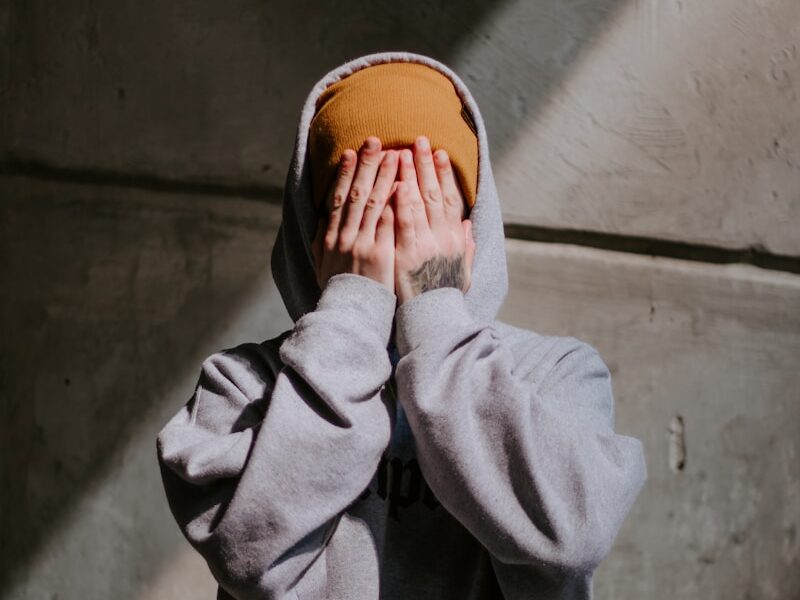 person in gray hoodie wearing brown leather shoes