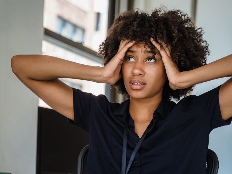 Young businesswoman looking stressed at her desk in a modern office.