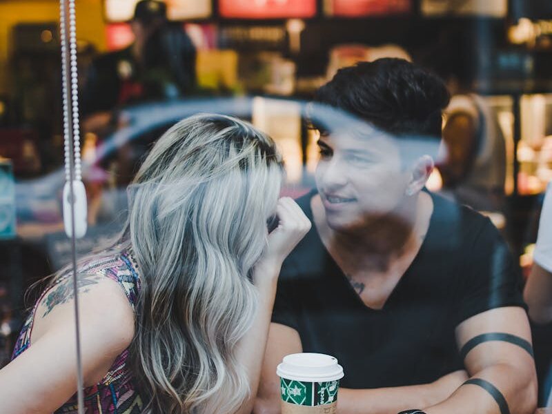 A couple enjoying a coffee date inside a modern café with smiles and conversation.