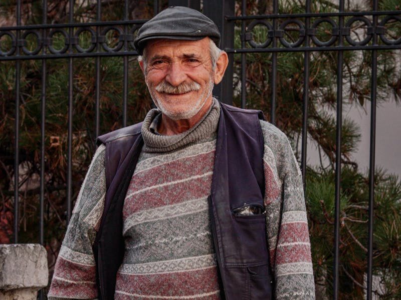 A cheerful street vendor selling traditional Turkish simits in Ankara, Turkey.