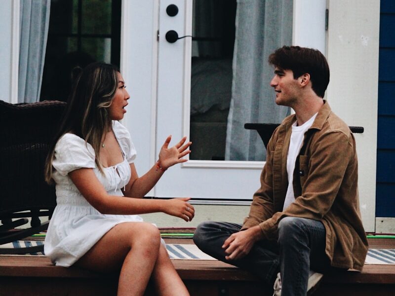 a man and woman sitting on a porch
