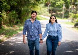 A man and a woman walking down a road holding hands