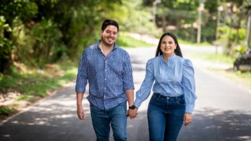 A man and a woman walking down a road holding hands