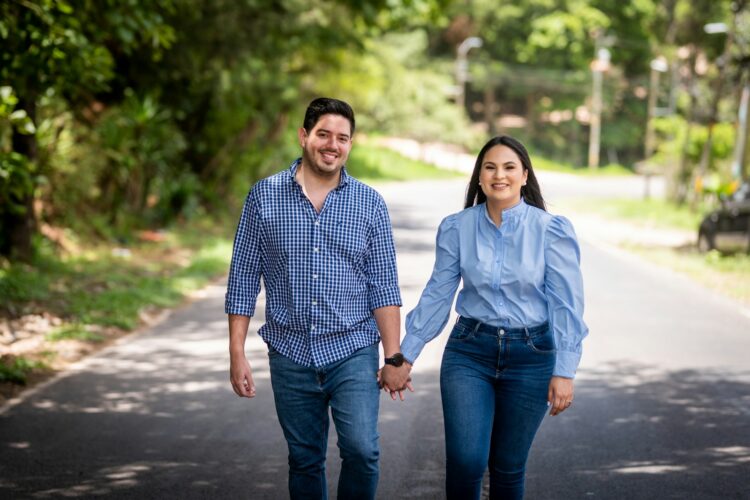 A man and a woman walking down a road holding hands
