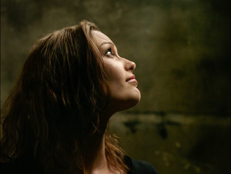 Elegant side profile of brunette woman looking upwards in a contemplative mood.