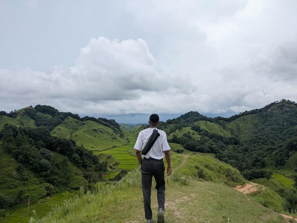 Traveler walking towards the lush green valleys surrounded by tranquility and calmness