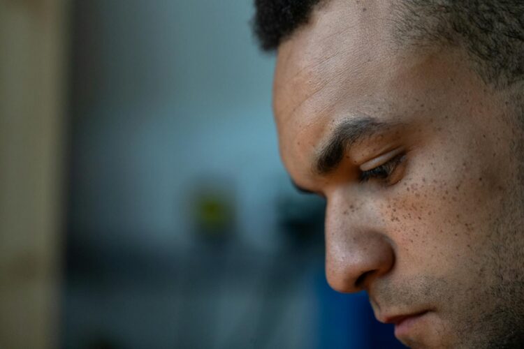Close-up portrait of a man deep in thought, showcasing focus and concentration indoors.