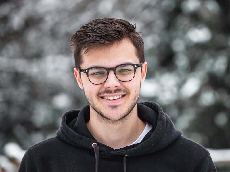 man in black hoodie wearing black framed eyeglasses
