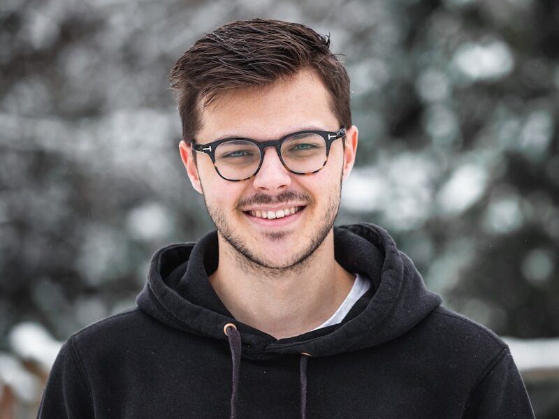 man in black hoodie wearing black framed eyeglasses