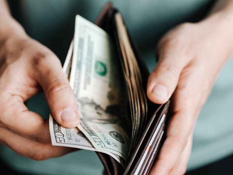 Close-up of hands holding a wallet with cash, depicting financial management.