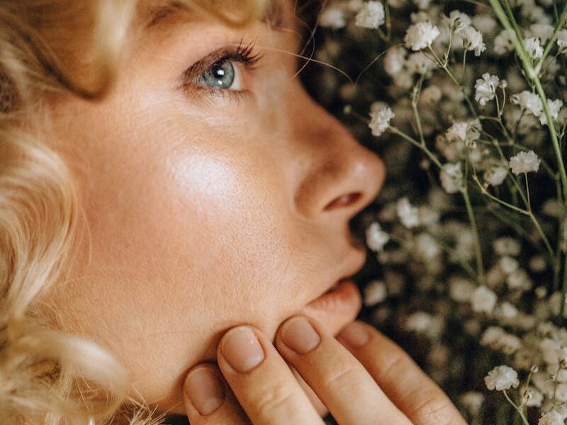 A detailed portrait showcasing a woman's face amid white flowers and curls, highlighting her serene expression.