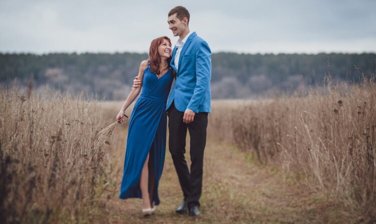 a man and woman posing for a picture in a field