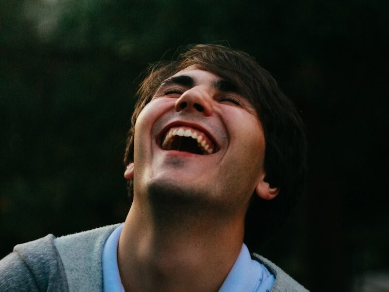 man in gray sweater smiling